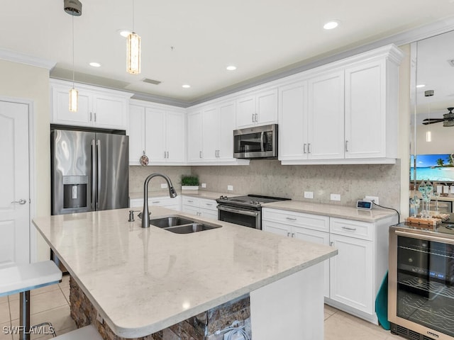 kitchen with a kitchen bar, appliances with stainless steel finishes, wine cooler, and sink