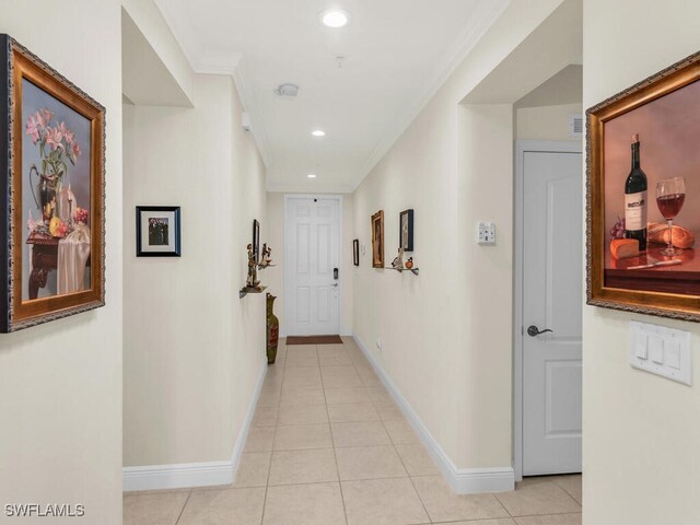 hallway featuring light tile patterned floors and crown molding