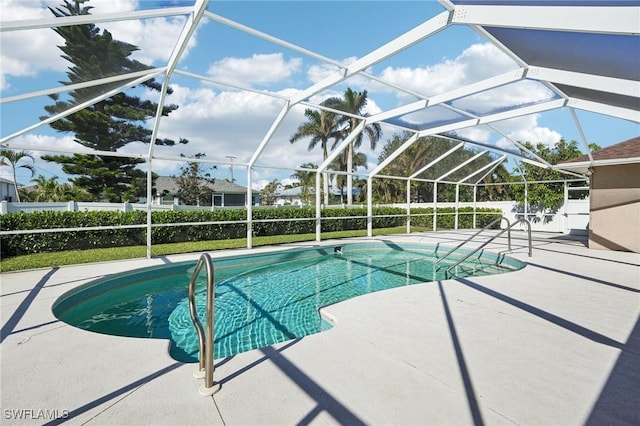 view of pool with glass enclosure and a patio area