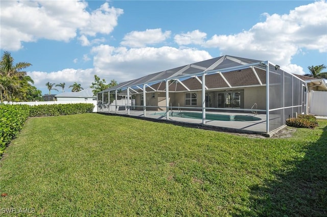 rear view of property with glass enclosure and a lawn