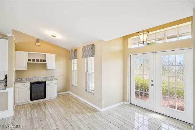 kitchen with white cabinetry, beverage cooler, a healthy amount of sunlight, and vaulted ceiling