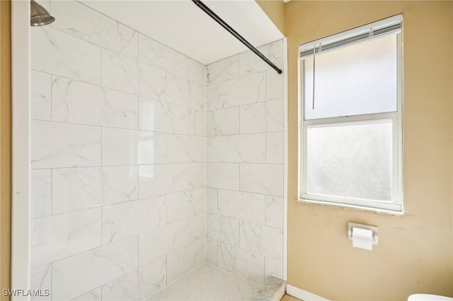 bathroom with toilet and tiled shower