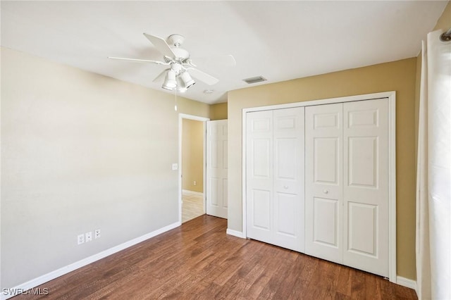 unfurnished bedroom with ceiling fan, wood-type flooring, and a closet