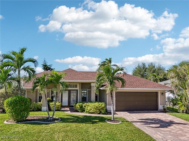 view of front of house with a front yard, french doors, and a garage