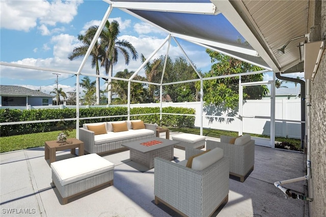 view of patio / terrace featuring a lanai and an outdoor living space with a fire pit