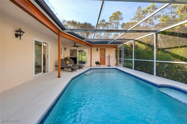 view of swimming pool featuring glass enclosure and a patio area