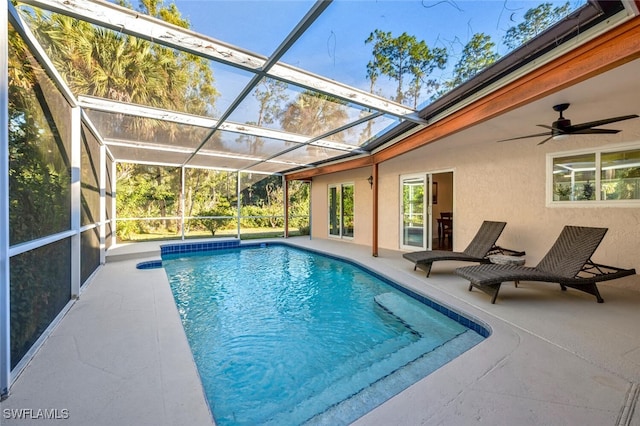 view of pool with glass enclosure and a patio