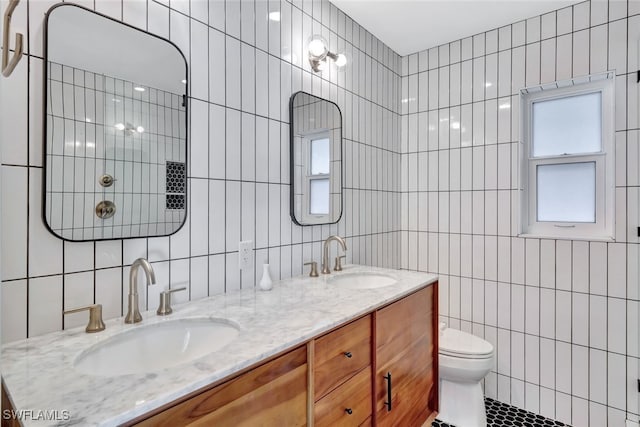 bathroom with tile patterned floors, vanity, toilet, and tile walls