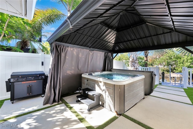 view of patio / terrace with grilling area and a hot tub