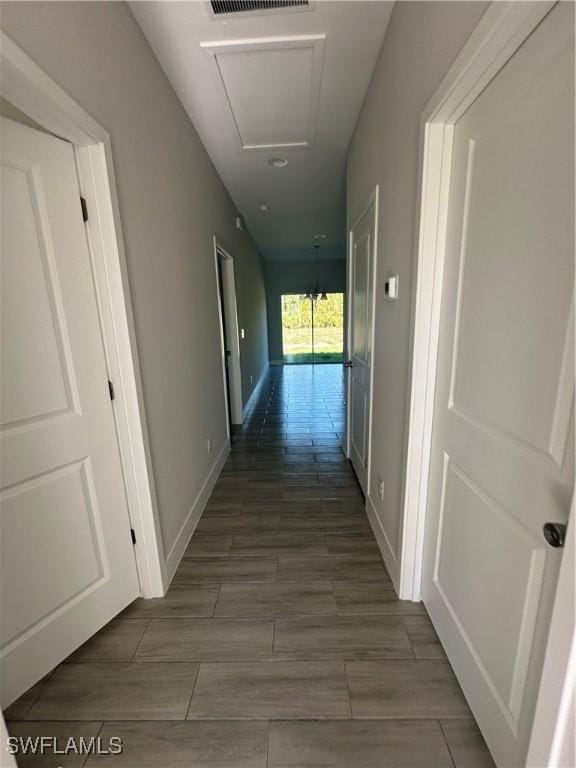 hall with dark hardwood / wood-style flooring and an inviting chandelier