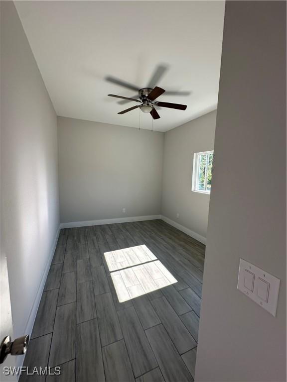 unfurnished room featuring dark hardwood / wood-style floors and ceiling fan