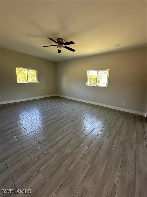 unfurnished room with hardwood / wood-style flooring, ceiling fan, and a healthy amount of sunlight