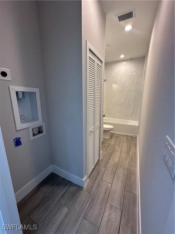 bathroom with tiled shower / bath combo and toilet