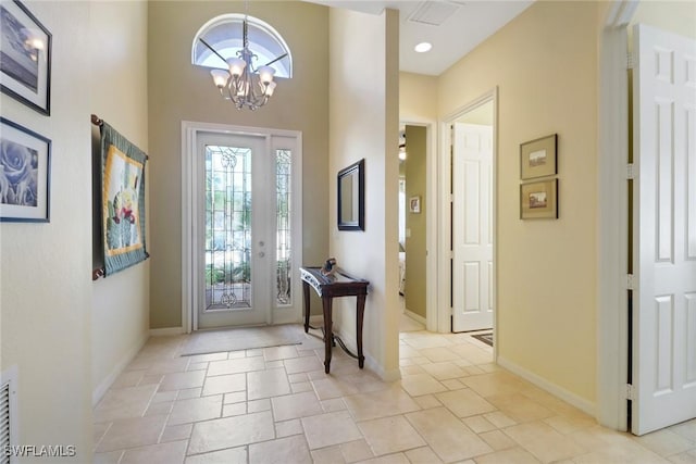 entryway with a high ceiling and a notable chandelier