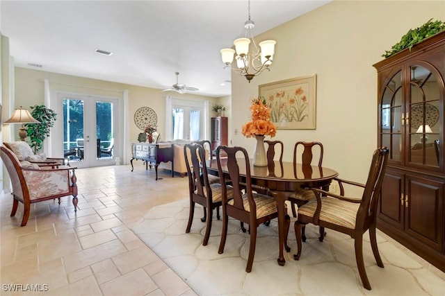 dining space featuring french doors and ceiling fan with notable chandelier