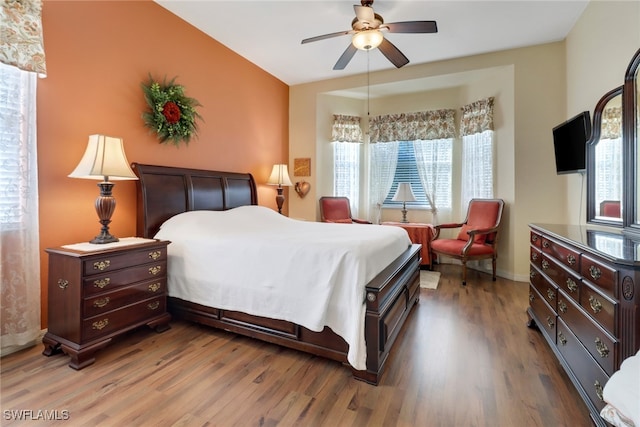 bedroom with hardwood / wood-style floors, multiple windows, and ceiling fan