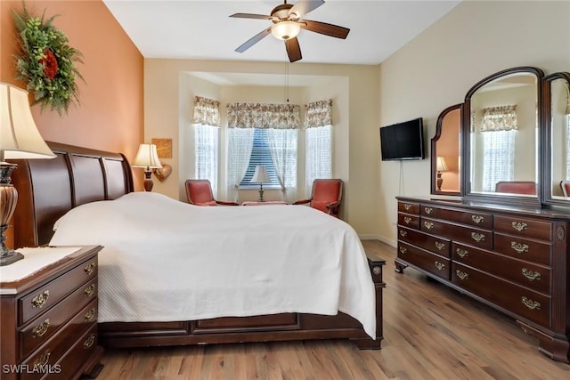 bedroom featuring hardwood / wood-style floors, multiple windows, and ceiling fan