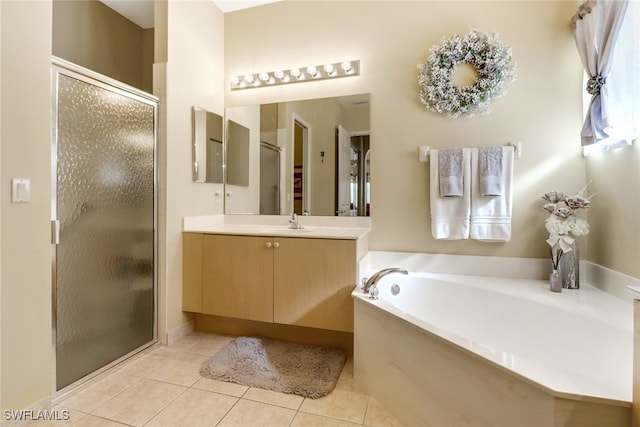 bathroom with tile patterned flooring, shower with separate bathtub, and vanity