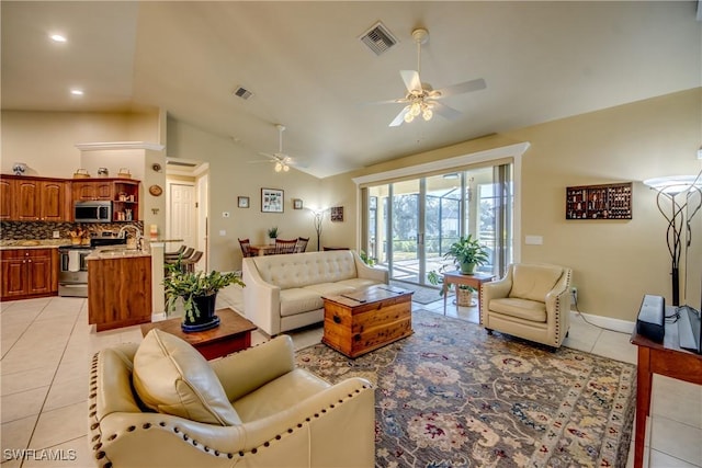 living room with ceiling fan, sink, light tile patterned floors, and vaulted ceiling