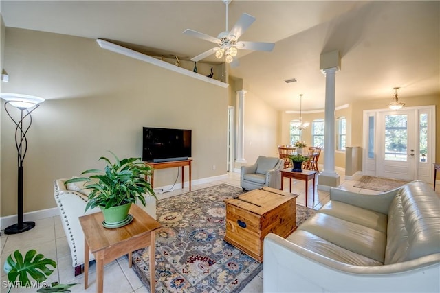 living room with ceiling fan with notable chandelier, decorative columns, lofted ceiling, and light tile patterned flooring