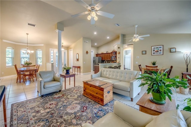 tiled living room with ceiling fan with notable chandelier and lofted ceiling