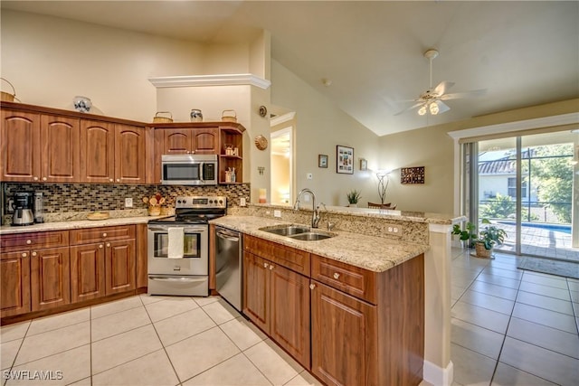 kitchen with sink, kitchen peninsula, stainless steel appliances, and high vaulted ceiling