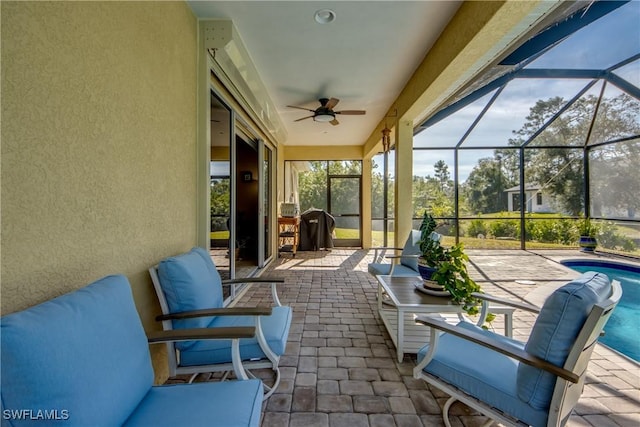 sunroom / solarium with ceiling fan and a swimming pool