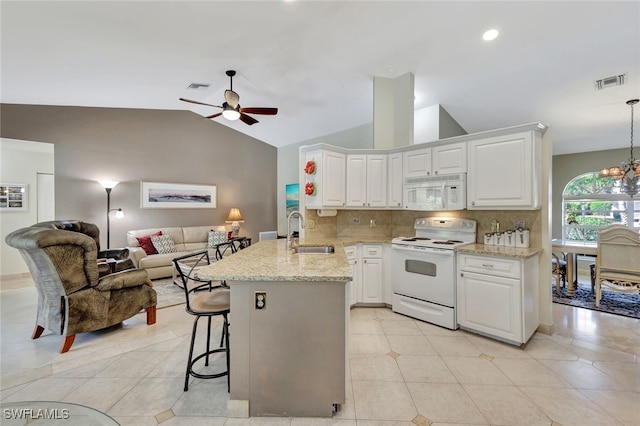 kitchen featuring kitchen peninsula, white appliances, ceiling fan with notable chandelier, sink, and white cabinets