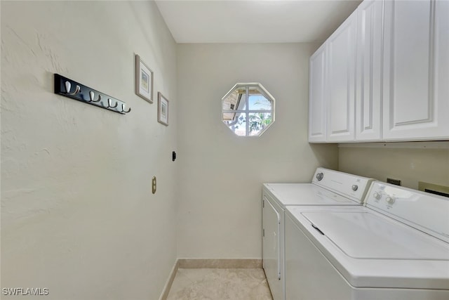 washroom with cabinets, washing machine and dryer, and light tile patterned flooring