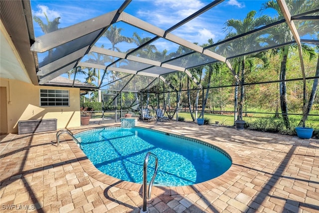 view of swimming pool with a lanai and a patio