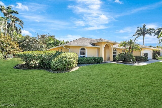 view of front of property with a garage and a front lawn