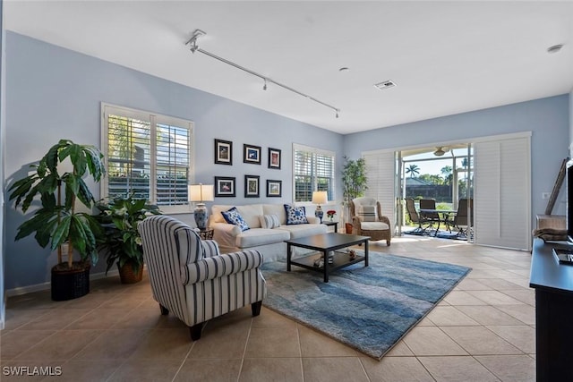 living room with light tile patterned floors, track lighting, and a healthy amount of sunlight