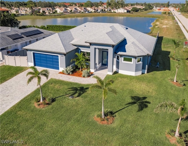 view of front facade featuring a water view, a garage, and a front lawn