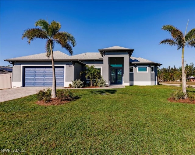 view of front facade featuring a garage, a front yard, and french doors