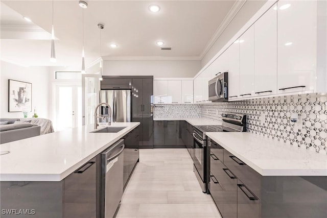 kitchen featuring white cabinetry, sink, hanging light fixtures, a kitchen island with sink, and appliances with stainless steel finishes