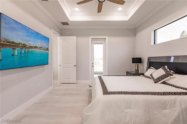 bedroom featuring a raised ceiling, multiple windows, crown molding, and ceiling fan