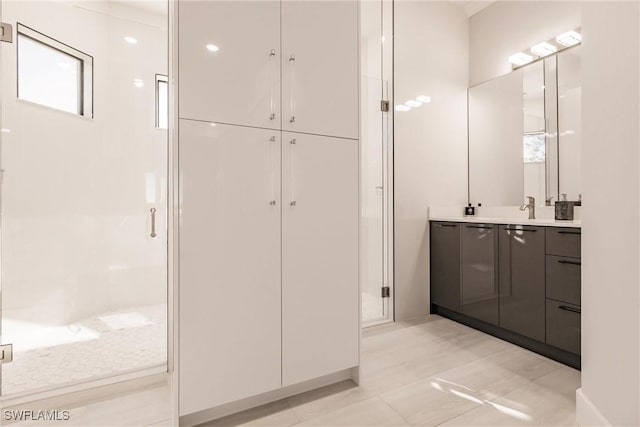 bathroom featuring tile patterned flooring, vanity, and walk in shower