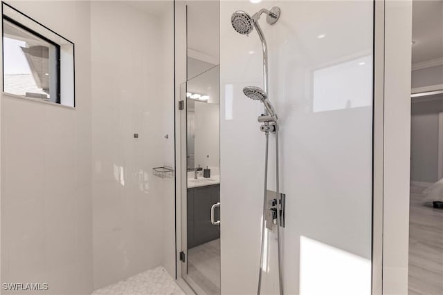 bathroom featuring crown molding, vanity, a shower with shower door, and wood-type flooring