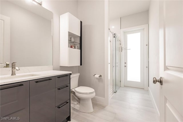 bathroom with vanity, toilet, and a shower with door