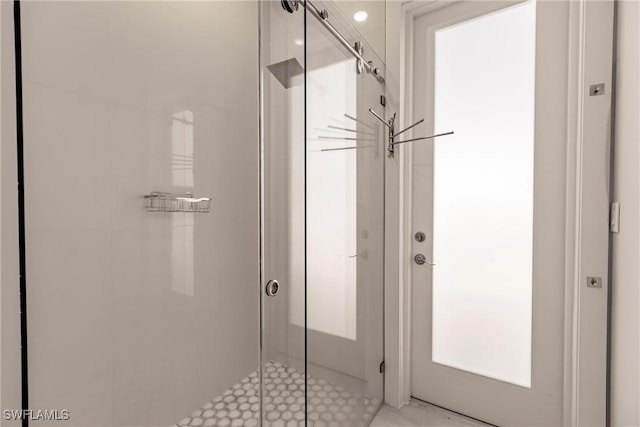 bathroom with a shower with door