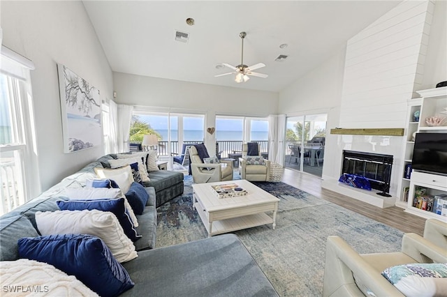 living room featuring hardwood / wood-style flooring, high vaulted ceiling, and ceiling fan