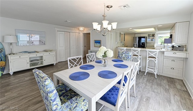 dining space featuring a chandelier, dark hardwood / wood-style flooring, and sink