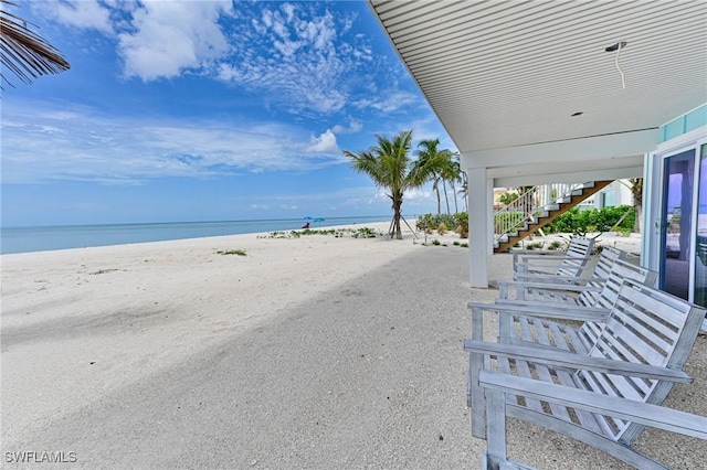 view of patio with a water view and a view of the beach