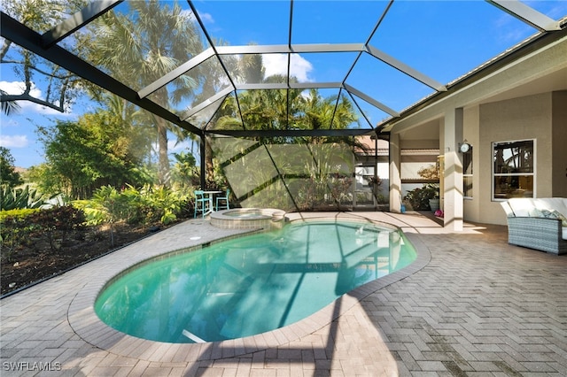 view of pool with an in ground hot tub, glass enclosure, and a patio area