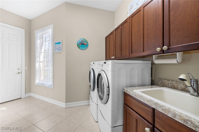 washroom with cabinets, light tile patterned flooring, washer and dryer, and sink