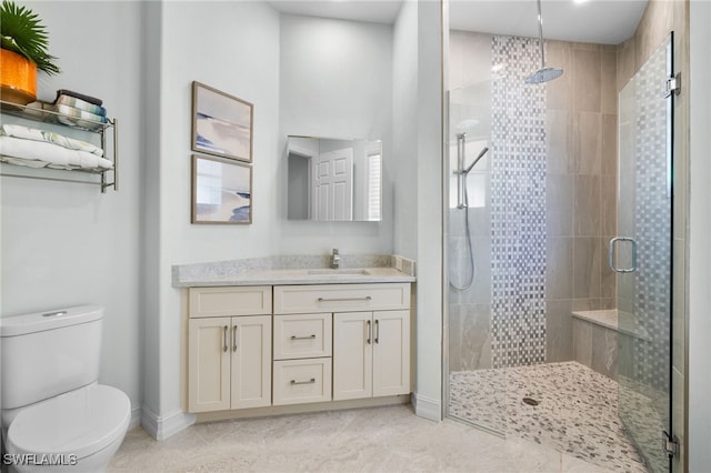 bathroom with tile patterned floors, vanity, toilet, and a shower with shower door