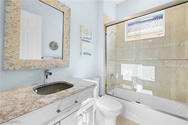 full bathroom featuring shower / bath combination with glass door, tile patterned floors, vanity, and toilet