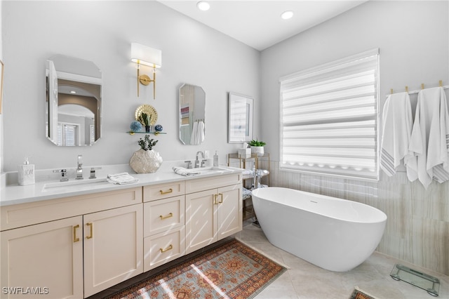 bathroom with tile patterned flooring, vanity, a bathtub, and tile walls