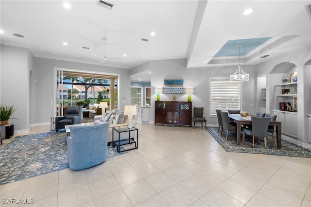 living room featuring ceiling fan with notable chandelier and crown molding