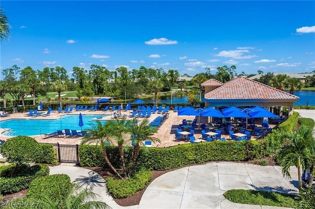 view of swimming pool featuring a water view and a patio